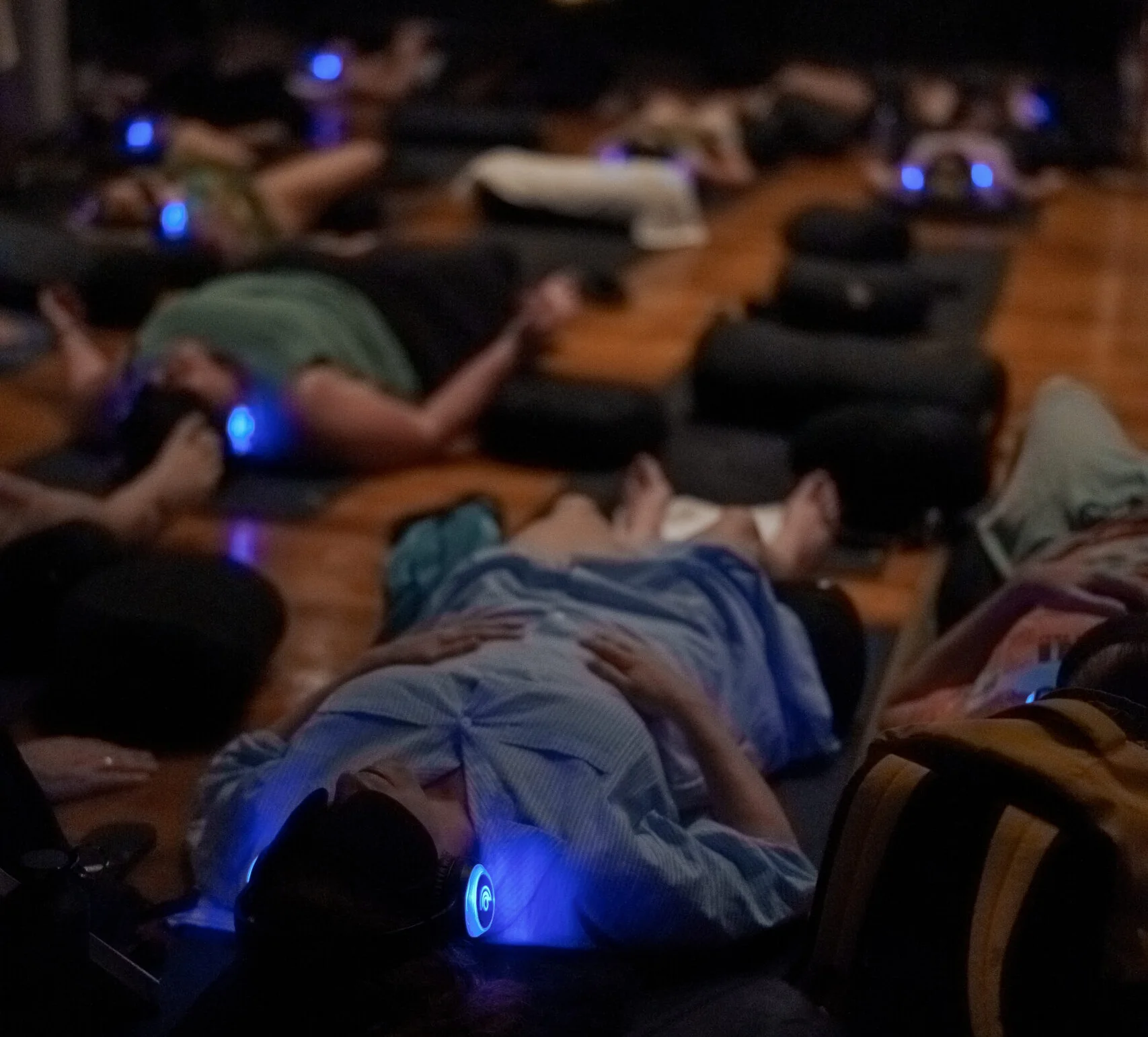 9D Breathwork participants lying down with glowing headphones